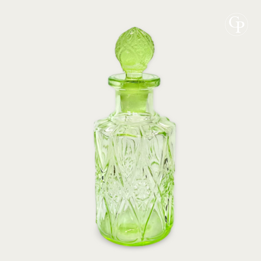 Elegant Val Saint Lambert Ouraline uranium glass perfume bottle with original pineapple stopper, glowing chartreuse green, Art Deco period circa 1935. | Élégant flacon de parfum Val Saint Lambert en verre à l'uranium Ouraline avec son bouchon d'origine en forme de pomme de pin, lumineux vert chartreuse, période Art Déco vers 1935.