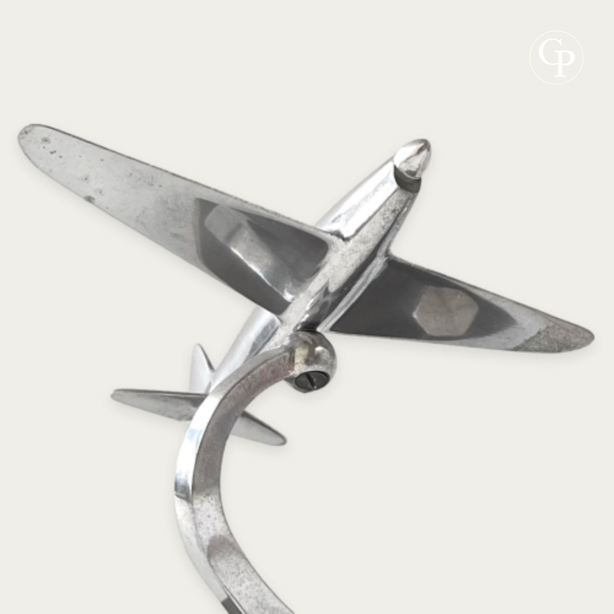 Close-up of the polished chrome airplane sculpture on an Art Deco lamp with a view of the curved stand and wings | Gros plan sur la sculpture d'avion en chrome poli d'une lampe Art Déco avec vue sur le support courbé et les ailes