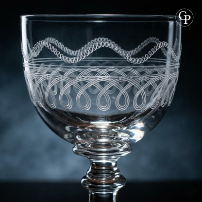 Gros plan sur la frise d'entrelacs et le décor guilloché d'un verre en cristal Val Saint Lambert modèle Lothaire | Close-up of the hand-engraved pattern and guilloche detail on a Val Saint Lambert Lothaire crystal glass