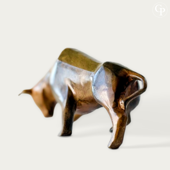Taureau cubiste en bronze massif par Pierre Chenet (vers 1970). Formes géométriques puissantes et belle patine à l’acide aux reflets bruns profonds, dorés et cuivrés sur fond blanc épuré.