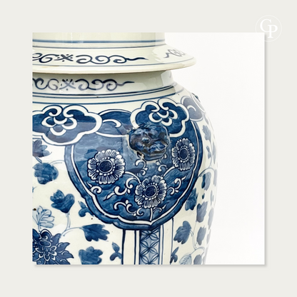Gros plan sur l'épaulement du vase balustre du XIXe siècle montrant une tête de lion gardien en relief, la bordure du couvercle et les décors floraux en bleu de cobalt | Close-up of the 19th-century baluster vase shoulder showing a relief guardian lion head, lid rim, and cobalt blue floral patterns